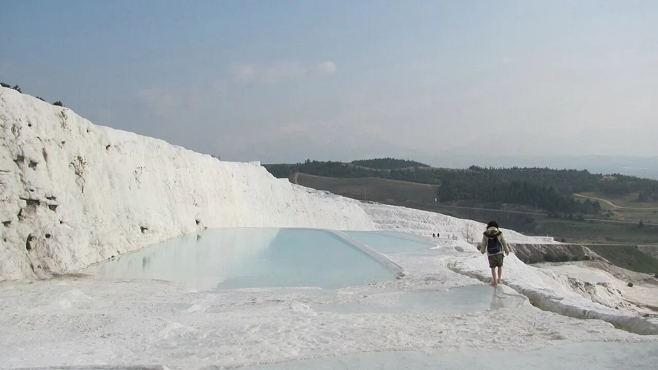 White travertine terraces and shallow pools at Pamukkale in Türkiye.