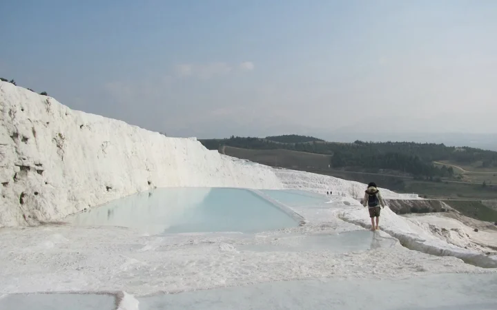 White travertine terraces and shallow pools at Pamukkale in Türkiye.