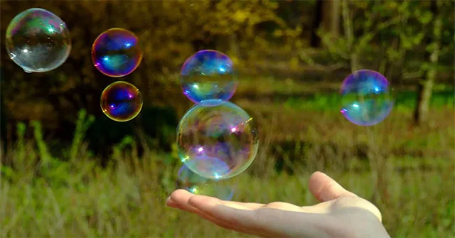 Colored soap bubbles above an outstretched hand